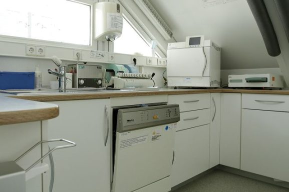 Moderne Küche mit weißem Geschirrspüler, Arbeitsfläche und verschiedenen Küchengeräten.