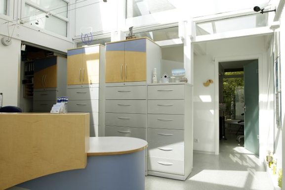 Heller Empfangsbereich mit modernen Schränken und Zugang zu einem weiteren Raum.